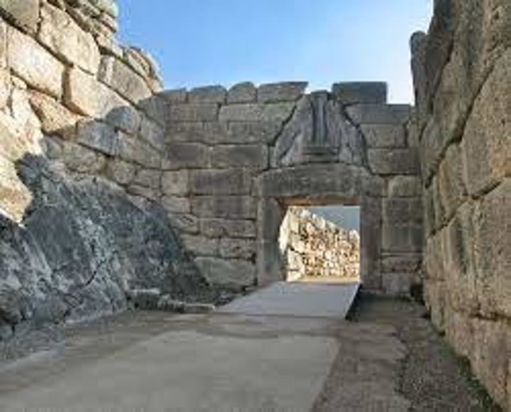 <p>The main entrance to Mycenae. In the triangle created by a corbel arch two lions are carved in relief. Their heads have not survived. The gate was at the top of an uphill slope, in order to tire out attackers.</p>