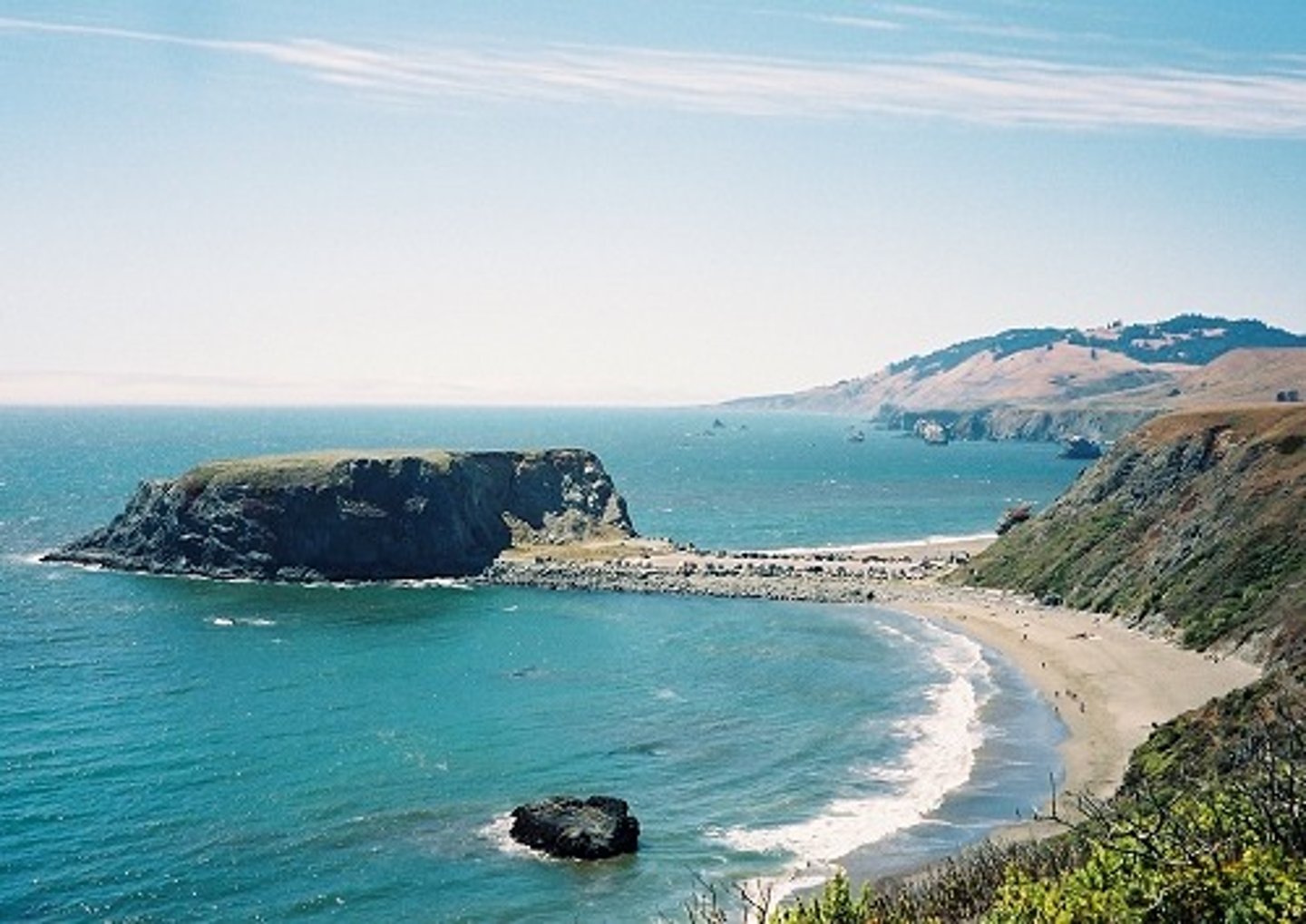 <p>Longshore drift causes an island to become joined to the mainland. A spit grows out from the mainland, which is due to the shape of the headland changing.</p>