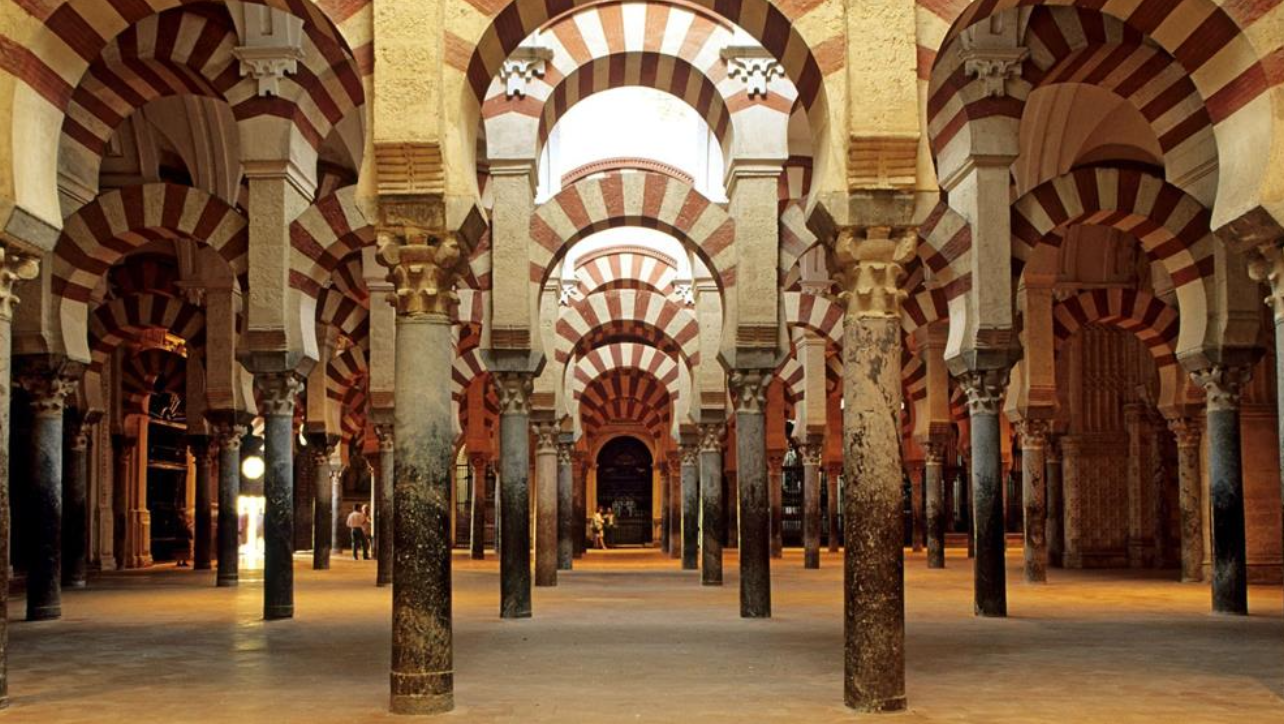 <p>An iconic example of Islamic architecture in Spain, showcases the cultural architecture of the Islamic with some Christian influence.</p><ul><li><p>Founded in 785 on the site of former Visogothic church (St. Vincent)</p></li><li><p>Expanded on by successors, until 900 (10th century)</p></li></ul><p>“Caliphal Islamic style” representative of art and architecture of the Caliphate of Córdoba</p><ul><li><p>Forest of Columns</p></li><li><p>Double-arch (horseshoe arch and semicircular)</p></li><li><p>Gives sense of air and space, with flat ceilings (feels taller than it is)</p></li><li><p>Repetition</p></li><li><p>Geometric and organic lines</p></li><li><p>Interlacing flowing, highly decorative</p></li><li><p>Stylized plant motifs</p></li><li><p>Alternating red and white, also gold</p></li><li><p>Use of stucco, wood, and recycled marble </p></li></ul><p>Mihrab (facing Mecca, ornate mosaic, hexagonal)</p><ul><li><p>Monumental, ribbed dome with ornate decoration</p></li></ul><p>(Perpetuity, meditation, intimacy, hypnotic effect Evocation of the divine.)</p>