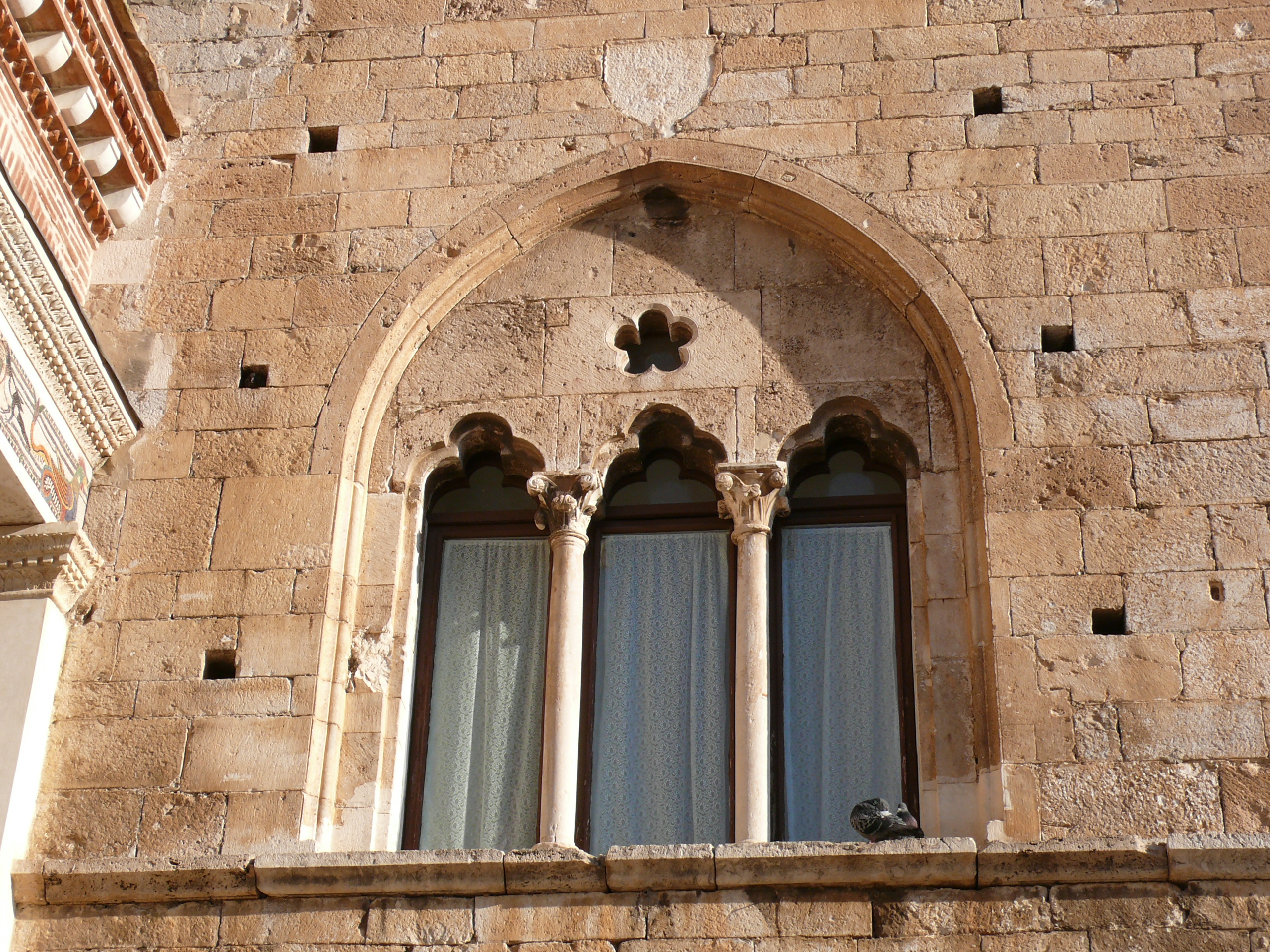 <p>È una finestra divisa in tre luci (aperture), separate da due pilastri o colonnine. La parola deriva dal latino "triforium", composto da "tri" (tre) e "foris" (apertura). In architettura è un elemento caratteristico di molti edifici, soprattutto chiese, dove funge da finestra o come apertura verso una galleria (il triforio). (La stessa cosa vale per le bifore e quadrifore)</p>