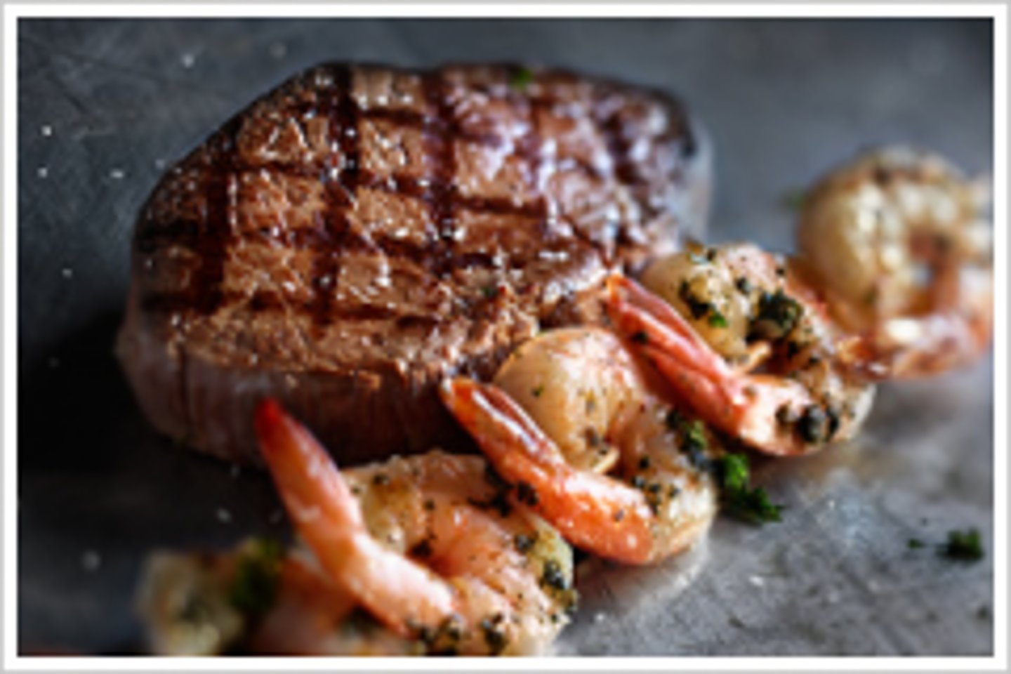 <p>a 6 oz sirloin (cooked to the guest's liking) and a skewer of shrimp. Served over our toasted fresh-baked bread.<br>Garlic butter and lemon wedge<br>warm large oval</p>