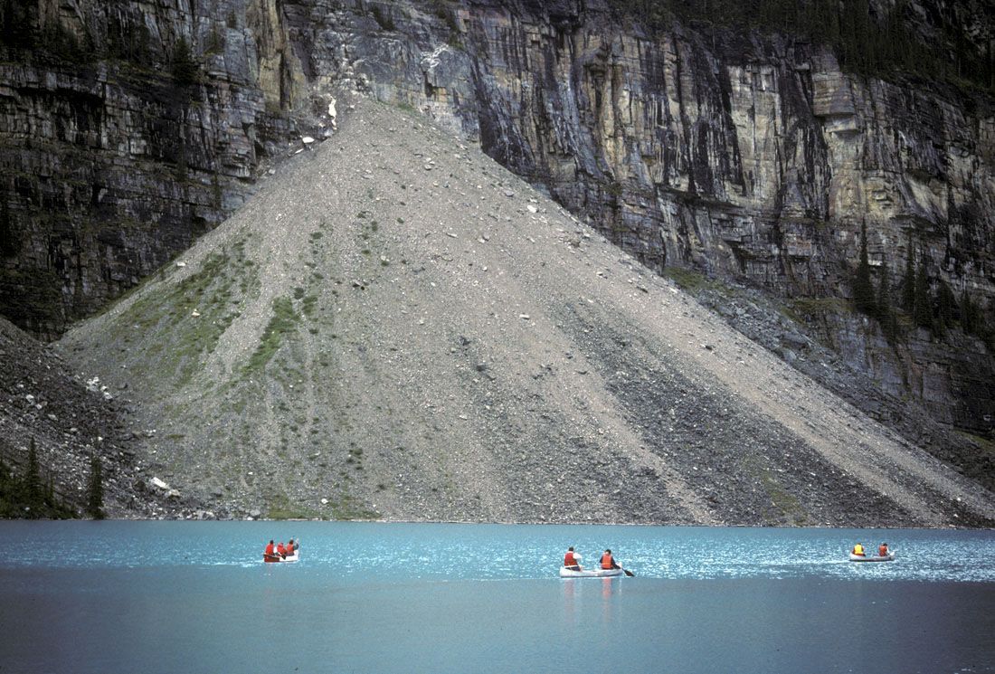 a pile of angular rocks and sediment from a rockfall at the base of cliff