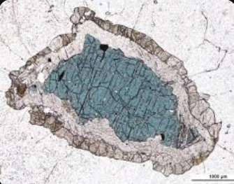 <p>textural features in metamorphic rocks formed by reactions at the boundary between minerals, resulting in a rim of new minerals around a mineral core. </p>