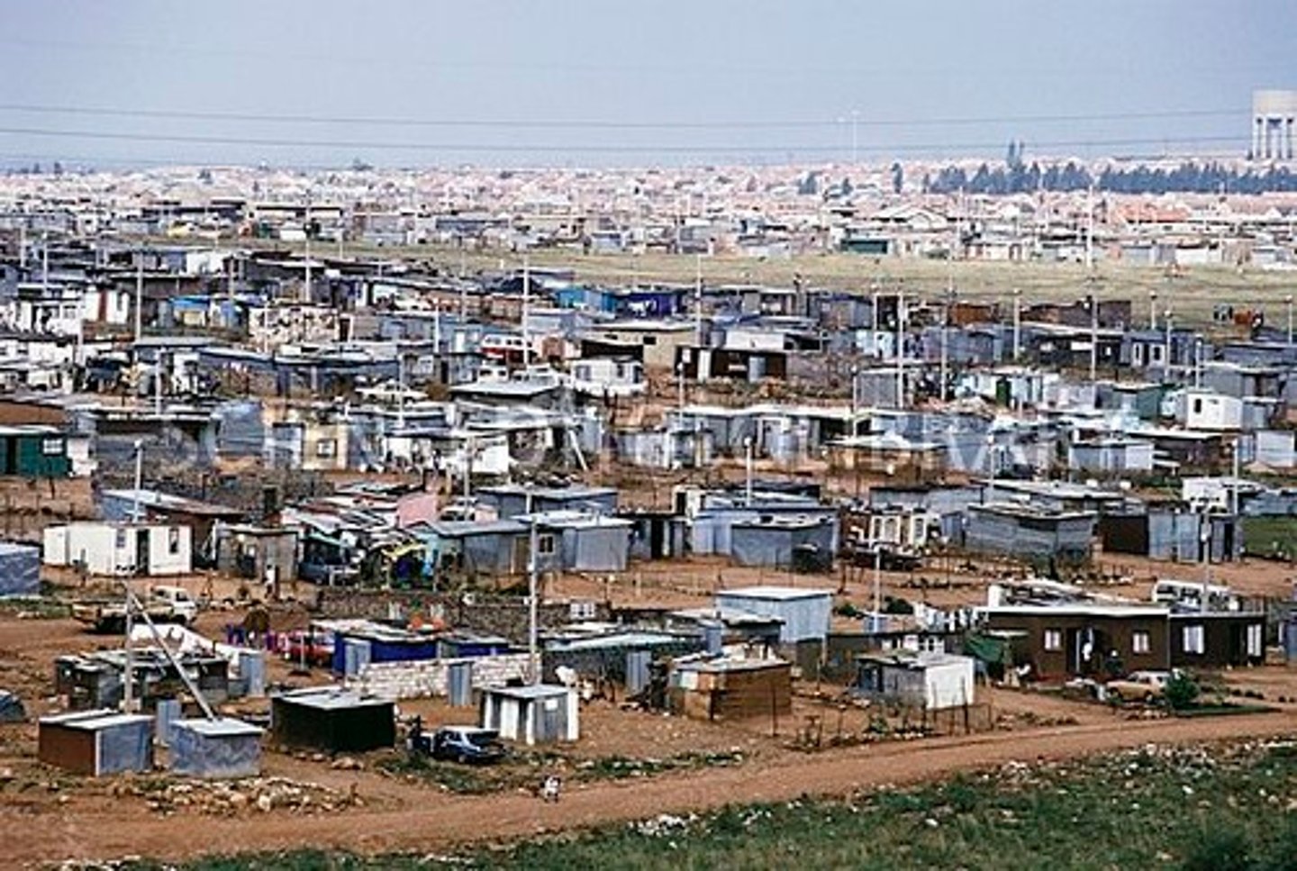 <p>housing built on land not owned, including slum and shanty town settlements.</p>