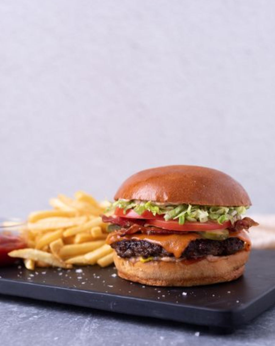 <p>Certified Angus Beef Patty, Cheddar cheese, Lettuce,  Smoked bacon, Relish-mayo, Mustard ➔ Brioche bun (or gluten free bun available),  Pickle,  Tomato,   Ketchup, Sea Salted Fries</p>