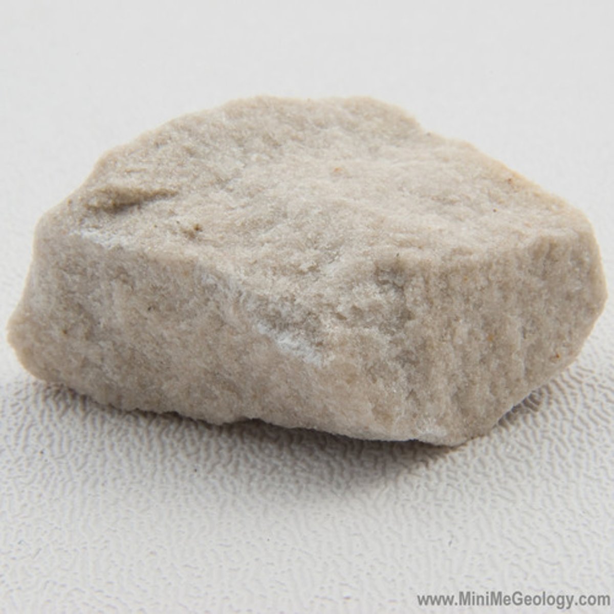 <p>Mineral grains are barely visible with a hand lens or low power microscope. Grains are too small to identify except as indicated by dark or light color. Quartz, feldspars, and clays are the most common. Feels rough when scraped by a fingernail, like an unglazed flowerpot.</p>