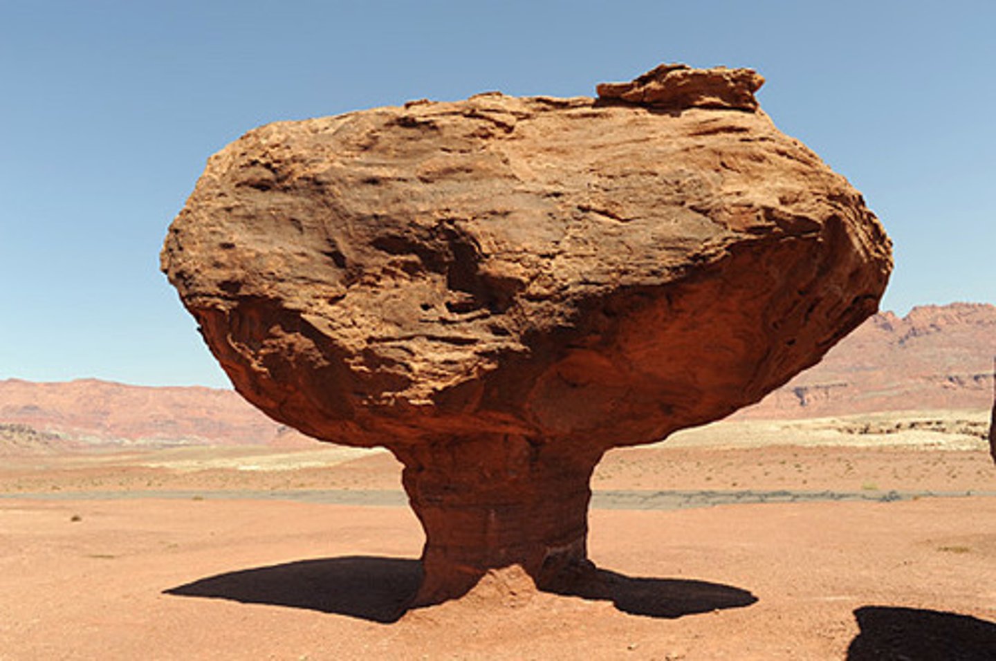 <p>a mushroom-shaped rock formed by the erosion of the rock's base</p><p>a type of ventifact</p>