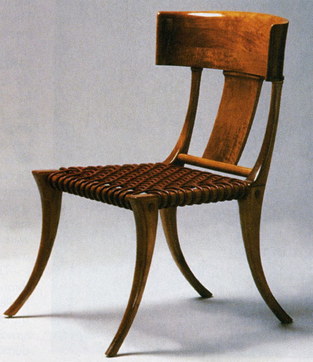 <p>Greek</p><p>A classical greek chair for women w/ concave back rest and splayed/ saber legs</p>