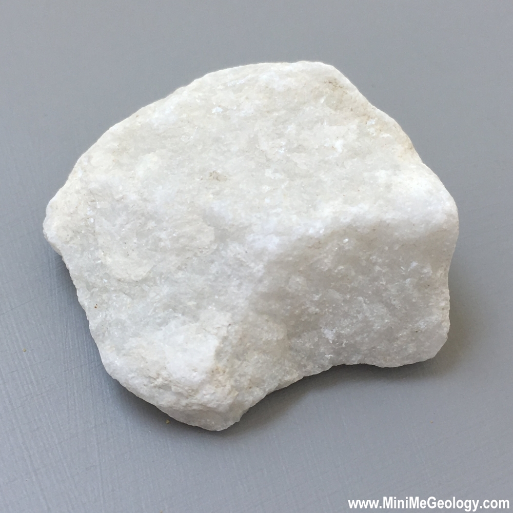 <p><span style="font-family: sans-serif">Metamorphic rock: </span><strong>marble</strong></p><p><strong> Marble</strong> is a <a target="_blank" rel="noopener noreferrer nofollow" href="https://geology.com/rocks/metamorphic-rocks.shtml"><strong>metamorphic rock</strong></a> that forms when <a target="_blank" rel="noopener noreferrer nofollow" href="https://geology.com/rocks/limestone.shtml"><strong>limestone</strong></a> is subjected to the heat and pressure of metamorphism. It is composed primarily of the mineral <a target="_blank" rel="noopener noreferrer nofollow" href="https://geology.com/minerals/calcite.shtml"><strong>calcite</strong></a> (CaCO<sub>3</sub>) and usually contains other minerals, such as clay minerals, micas, <a target="_blank" rel="noopener noreferrer nofollow" href="https://geology.com/minerals/quartz.shtml"><strong>quartz</strong></a>, <a target="_blank" rel="noopener noreferrer nofollow" href="https://geology.com/minerals/pyrite.shtml"><strong>pyrite</strong></a>, iron oxides, and <a target="_blank" rel="noopener noreferrer nofollow" href="https://geology.com/minerals/graphite.shtml"><strong>graphite</strong></a>.</p><p style="text-align: start">Under the conditions of metamorphism, the calcite in the limestone recrystallizes to form a rock that is a mass of interlocking calcite crystals. A related rock, dolomitic marble, is produced when <a target="_blank" rel="noopener noreferrer nofollow" href="https://geology.com/rocks/dolomite.shtml"><strong>dolostone</strong></a> is subjected to heat and pressure</p><p style="text-align: start"><span style="font-family: arial">Being composed of calcium carbonate, marble will react in contact with many acids, neutralizing the acid</span></p>