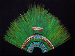 <p>The Ruler's feather headdress, likely belonging to Motecuhzoma II, is a stunning artifact of Aztec culture, exemplifying the artistic and spiritual significance of featherwork in Mesoamerican society. Crafted primarily from brightly colored feathers of the quetzal and cotinga birds, both highly valued for their vibrant hues and rarity, the headdress is adorned with intricate designs that symbolize power and divinity. The incorporation of gold elements further emphasizes the elite status of its wearer, as gold was a symbol of wealth and authority in Aztec culture. This ceremonial headpiece was worn during important rituals and events, signifying the ruler's connection to the gods and reinforcing his role as the spiritual leader of the Aztecs. The craftsmanship involved in creating such a headdress required exceptional skill, as feathers were meticulously arranged to create elaborate patterns, and the use of gold accentuated the overall aesthetic. The headdress not only served as a prestigious adornment but also played an essential role in the depiction of Aztec identity and the socioeconomic structures within their society. It remains one of the most iconic symbols of the Aztec civilization's artistic legacy.</p>