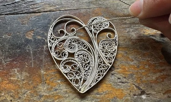<p>delicate, lace-like, ornamental work of intertwined wire</p>