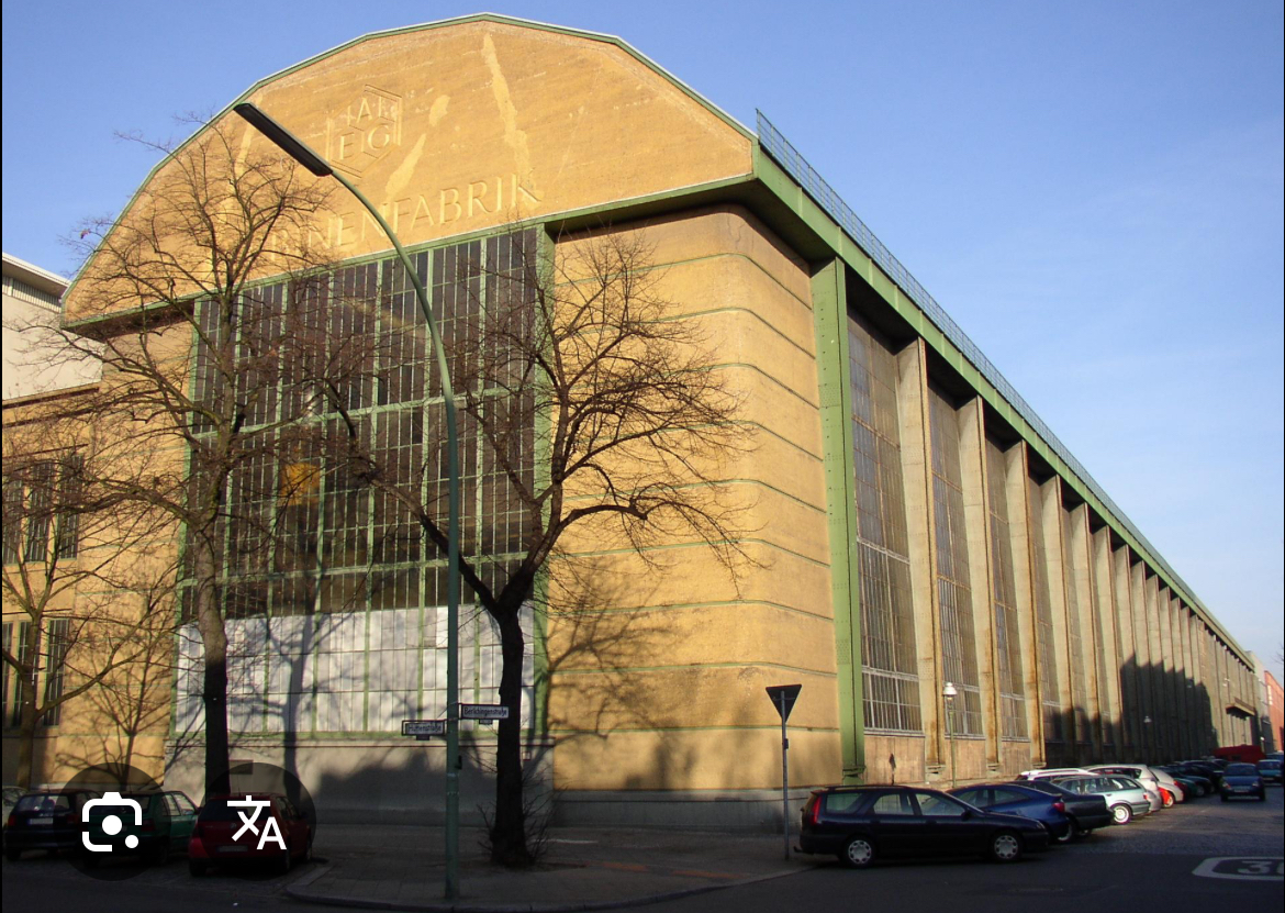 <p><span><span>Monumental industrial building, steel frame expressed, glass infill, temple-like proportions</span></span></p>