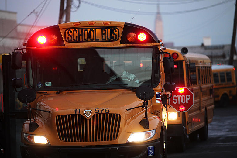 <p><strong>What does it mean when a school bus is stopped and its red lights are flashing?</strong></p>