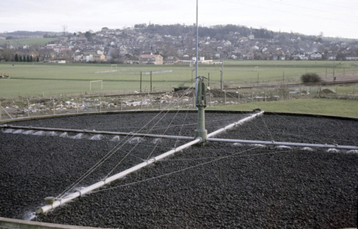 <p>Rotating arms spray the liquid effluent over gravel. </p><p>The surface area is maximised for microbes (bacteria, fungi, algae, invertebrates) that digest organic matter.</p><p>Some bacteria denitrify nitrates, reducing eutrophication.</p>