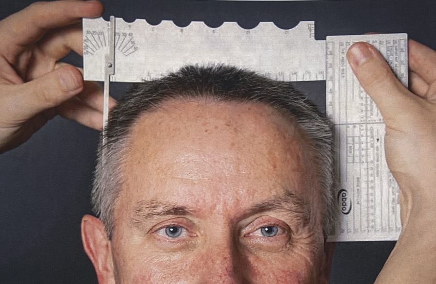 <p>Place the pointer at the ear point on the right side of the head and place a ruler perpendicular to the gauge at the ear point on the left side of the head. Read off the head width on the horizontal scale.</p>