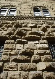 <p>a wall made of stone that is typically rough and raised of the wall surface</p>