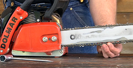 <p>Loosen the <strong>guide bar mounting nuts</strong> about one turn.</p>