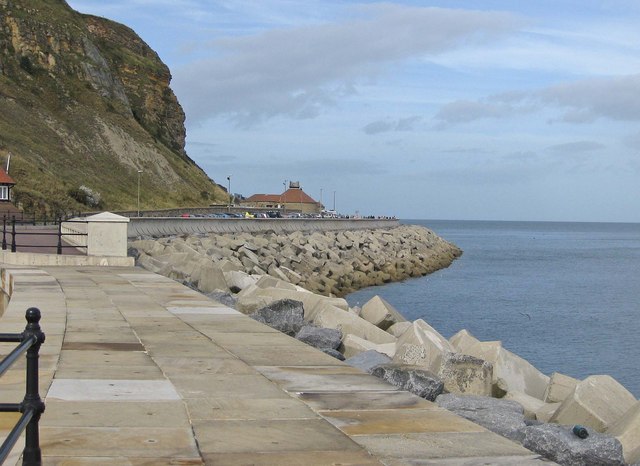 <p>large boulders at the bottom of a cliff or in front of a sand dune</p>