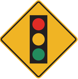 A traffic signal is at the intersection ahead. Slow down; poor visibility is likely. 