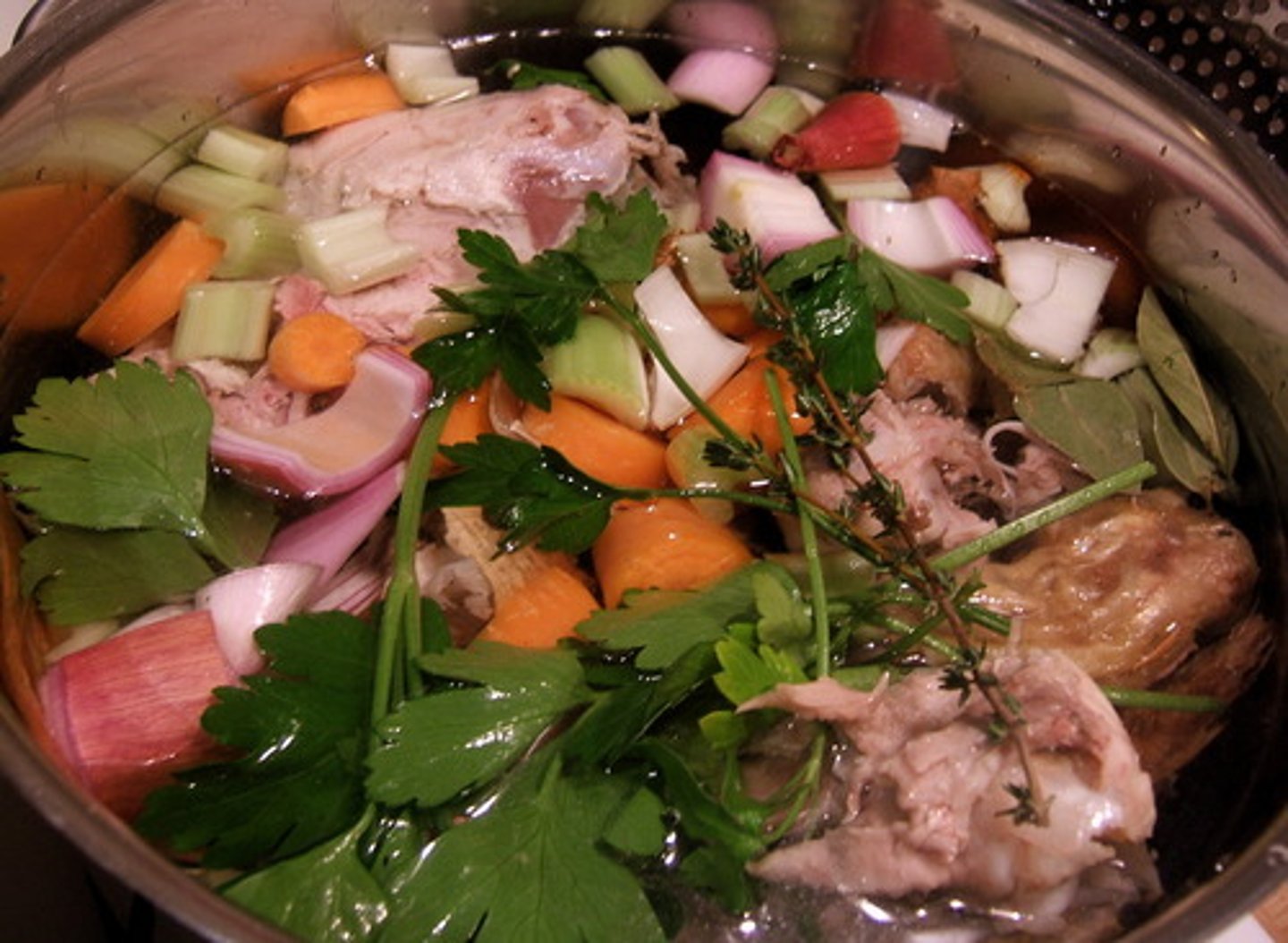 <p>mirepoix, leeks, turnips. Tomatoes, garlic, and seasonings may also be added to flavor or darken the stock, tomatoes strained with cheesecloth or filter so no seeds or skins get into stock.</p>