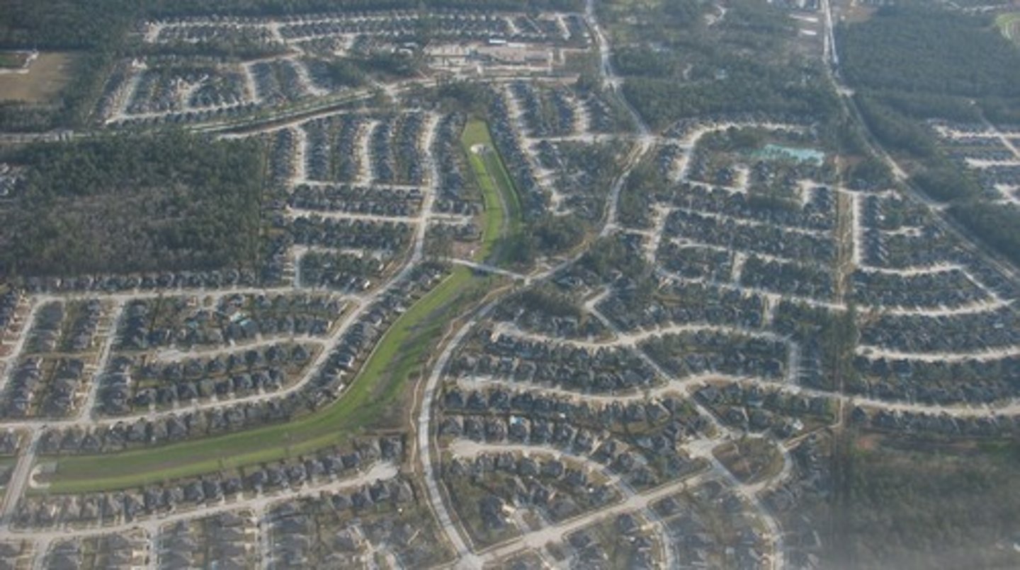 <p>The change in population distribution from high population density areas to low density suburbs that spread into rural lands, leading to potential environmental problems.</p>