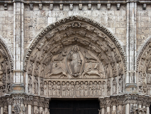 Half-round panel that fills the space between the lintle and arch over the doorway of the church. Relief carvings.