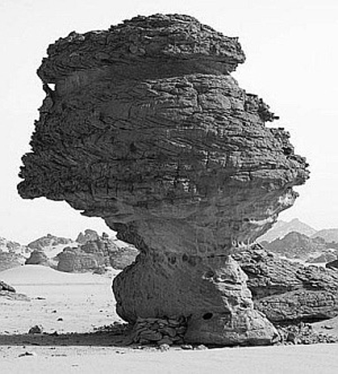 <p>ontstaan van bijzondere landschapsvormen zoals:</p><p>-Paddenstoelrotsen: rotsformaties waarbij onderste deel sneller afslijt dan bovenste, omdat zanddeeltjes vooral dicht bij de grond worden meegevoerd (bv. In White Desert in Egypte)</p><p>-Ventifacten ('windkeien'): gesteenten die door constante zandstraling glad en gepolijst zijn, vaak met scherpe, aerodynamische vormen (bv. Woestijnen van Namibië en ZW van V.S.)</p><p>De wind komt van beide kanten daarom is er een punt op de steen.</p>