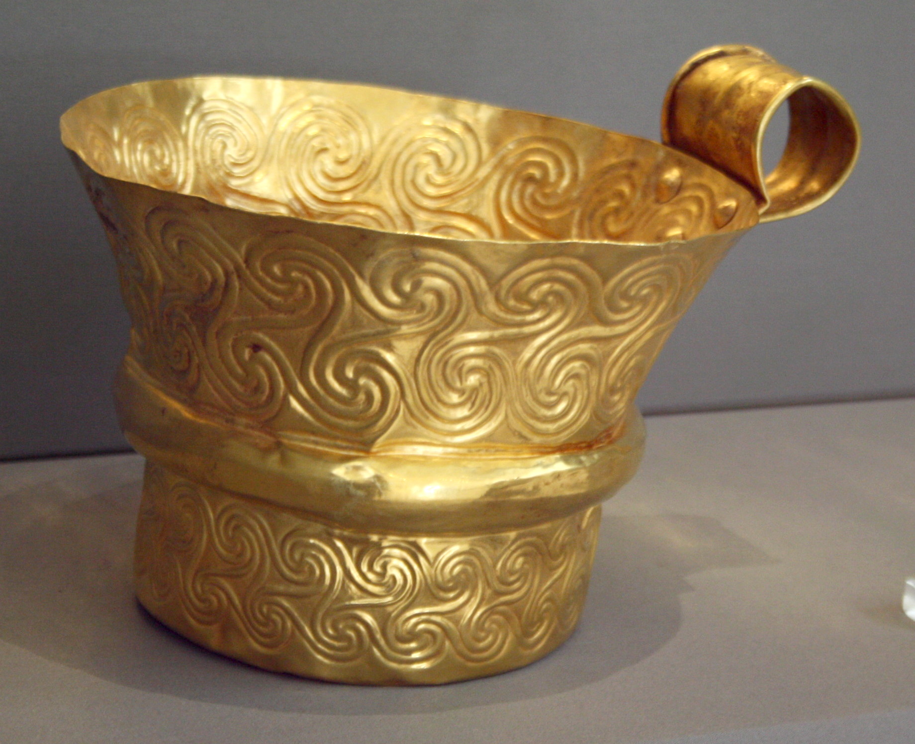 <p><strong><u>Date</u></strong> : 16th century BC </p><p></p><p><strong><u>Location</u></strong> : Grave Circle A, Mycenae </p><p></p><p><strong><u>Material</u></strong> : Gold </p><p></p><p><strong><u>Significance</u></strong> : </p><ul><li><p>evidence of <strong>metalworking skills</strong> ( repousse swirls ) </p></li></ul><p></p><ul><li><p>evidence of <strong>drinking culture</strong> - what <strong>types of vessels</strong> were used ? </p></li></ul><p></p><ul><li><p><strong>wealth</strong> of Mycenae ( <strong>gold cup </strong>) </p></li></ul><p></p>