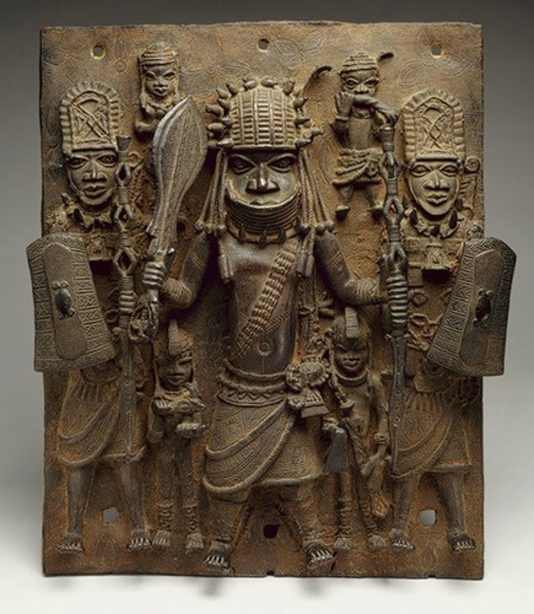 <p>Edo people, Cast Brass. (LOST WAX PROCESS BAYBEE) <br><br>Several hundred plaques to decorate walls, used to show lineage (didactic). OBA (king) descendant of the founding ancestor, flanked by attendants.<br>HIERARCHY OF SCALE!<br>Brass+metal= royalty<br>Beneficial trade W/ the Portuguese, coral and brass for cloth peppers and beads.</p>