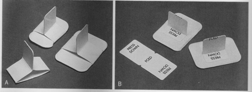 <p>A heavy paperboard tab or loop that is fitted around an intraoral receptor and is used to stabilize the receptor during the procedure.</p>