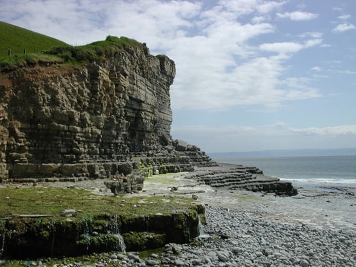 <p>A high, steep face of rock or earth</p>