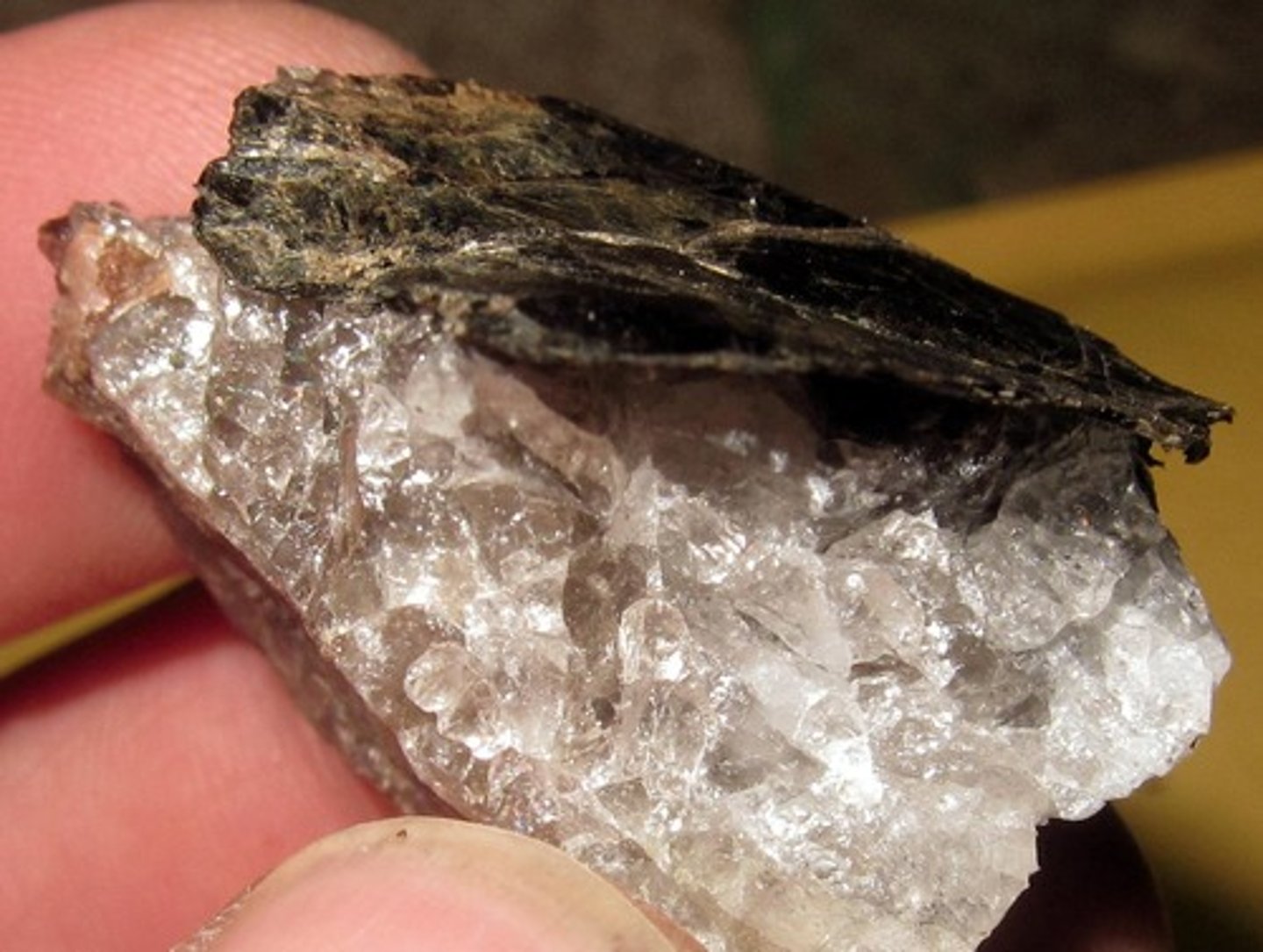 <p>(top black piece)</p><p>Mineral</p><p>Color: brown/black</p><p>Streak:</p><p>Layers: yes, flakes in thin sheets. It has perfect cleavage in one direction.</p><p>Texture: smooth</p><p>Shiny: glassy</p><p>Hardness: Moh's scale 2.5-3, can be scratched by a fingernail</p><p>Other:</p><p>nonmetalic</p><p>type of mica</p><p>Can be used in insulation</p><p>Color is caused by biologic materials exposed to oxygen as it cools.</p>