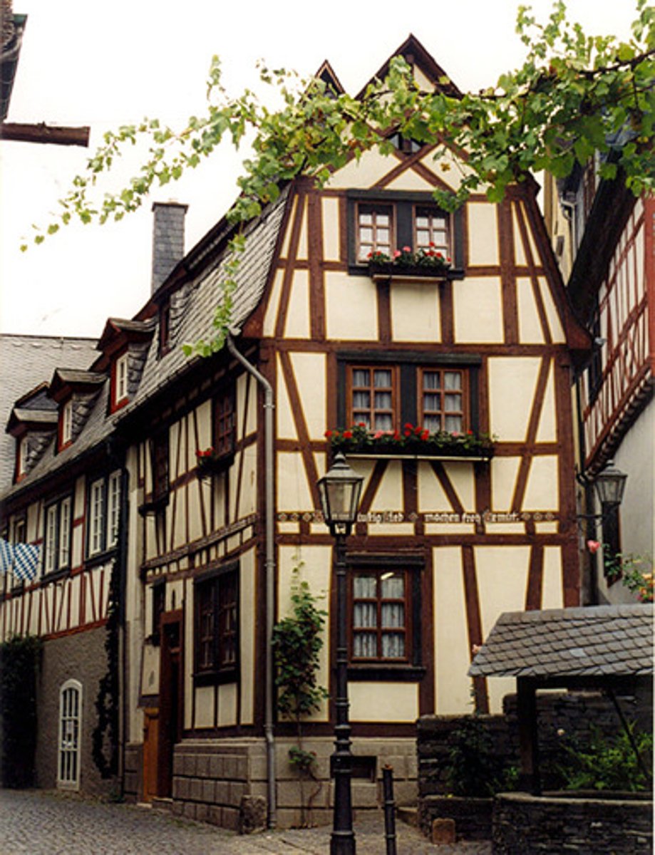 <p>having a timber framework with the spaces filled with masonry or plaster</p>