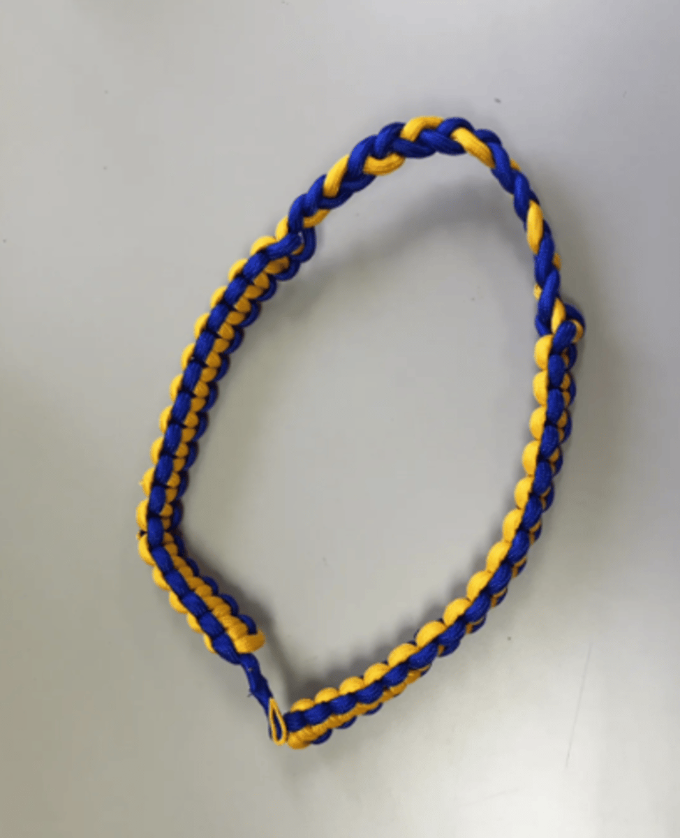 <p>- A single loop, square weave, blue and gold, multi-strand cord</p>