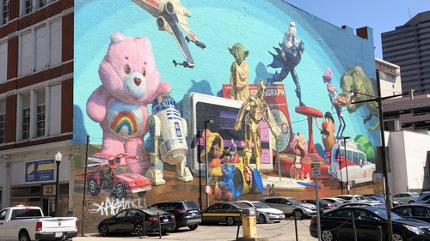 <p>a) Cincinnati based artist, hyper real style makes commentary on the products of Cincinnati history, such as the history of the toy industry</p>