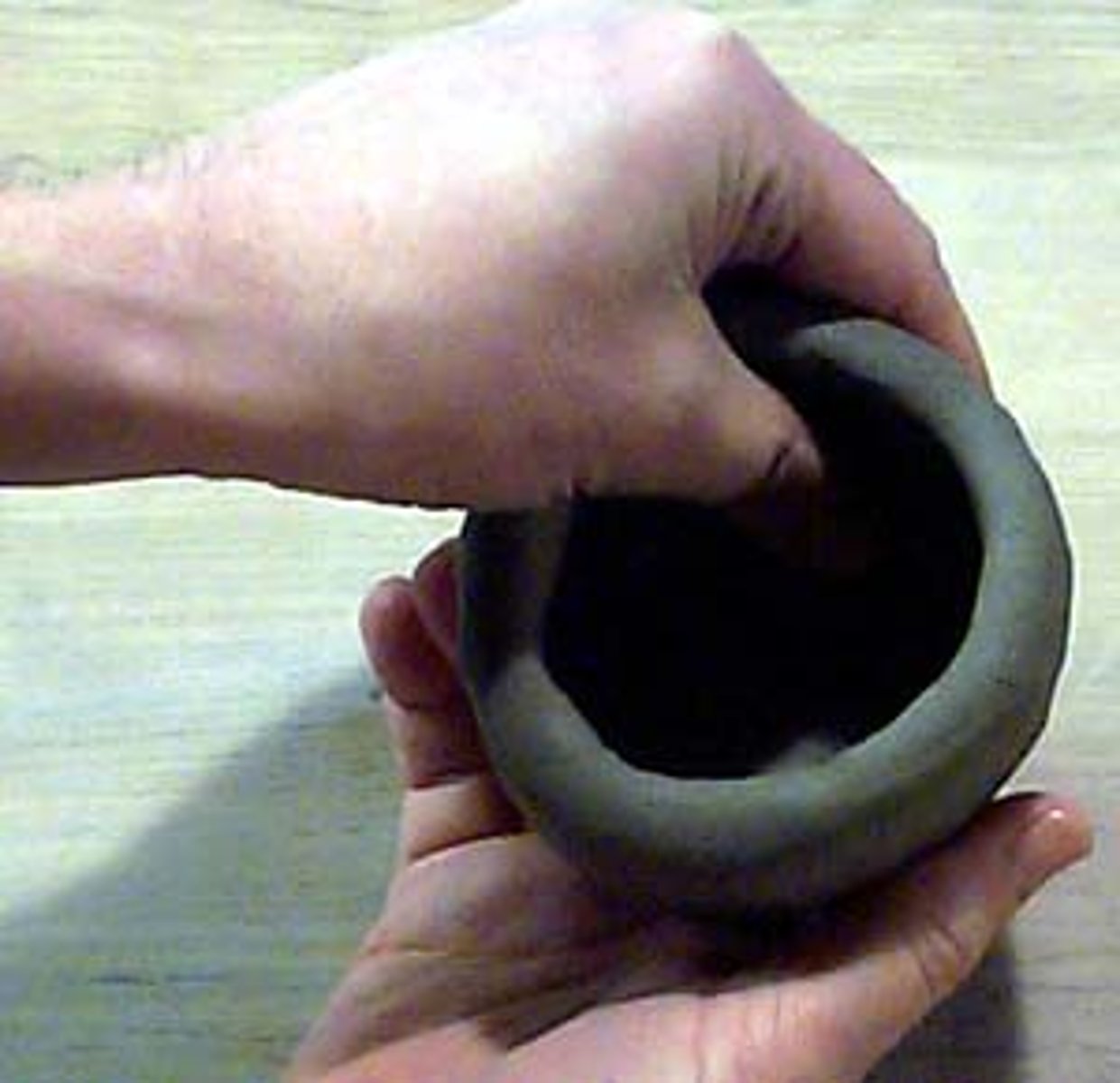 <p>created by rolling a ball of clay and then inserting a thumb into the ball.</p>