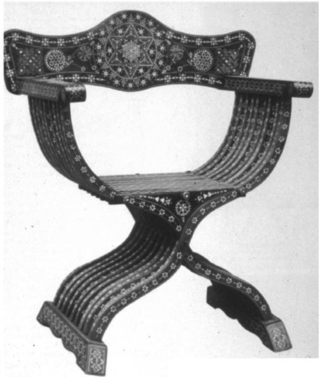 <p>What Gothic chair has seven serpentine X-shaped staves, secured by a runner foot and straight arms, with a flat arched back, slat seat, and loose cushion?</p>