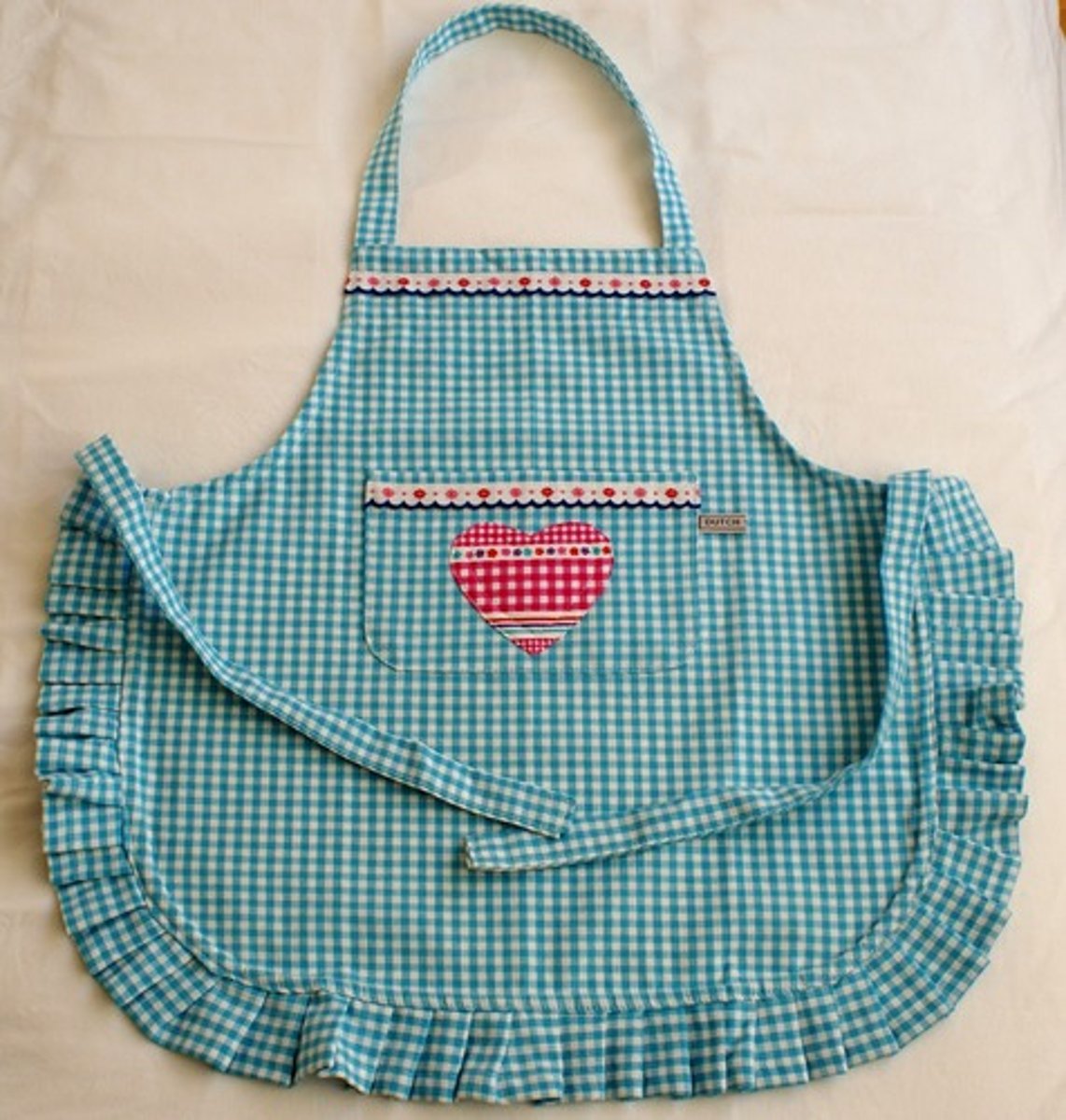 <p>фартух(a piece of clothing worn over the front of other clothes to keep them clean when doing a dirty or messy job, especially cooking)</p>