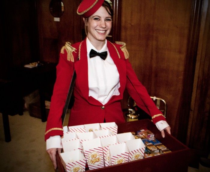<p>a woman who works in a theatre or cinema<span>, whose job is to show people to their seats and to sell sweets and drinks</span></p>