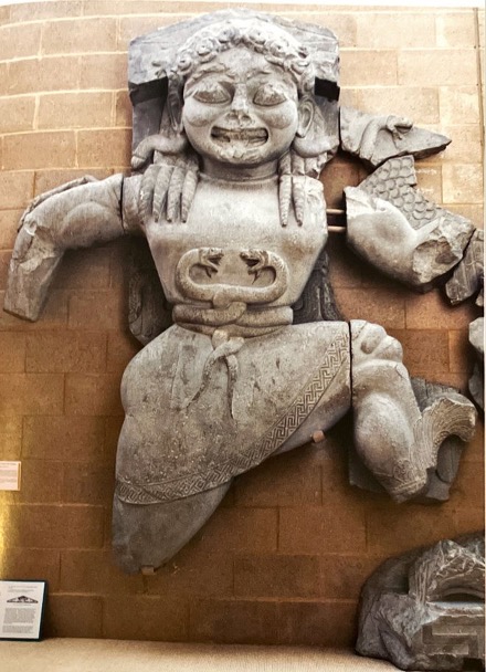 Aesthetics​:

* Depicted facing ahead, probably running from Perseus (though he is not depicted)​
* Wears a belt of two intertwined snakes (snakes show her demonic/monstrous nature)​
* Snakes on either side of her hair (her depictions in art are different from in literature)​
* Flanked by her children (Pegasus and Chrysaor) and two panthers (represent protection) who effectively fill the space in a crouched position​

Function:

* To be an apotropaic spirit (warding off evil), in doing so she is protecting the temple​
* Also, the snakes prevent malice from entering the temple​