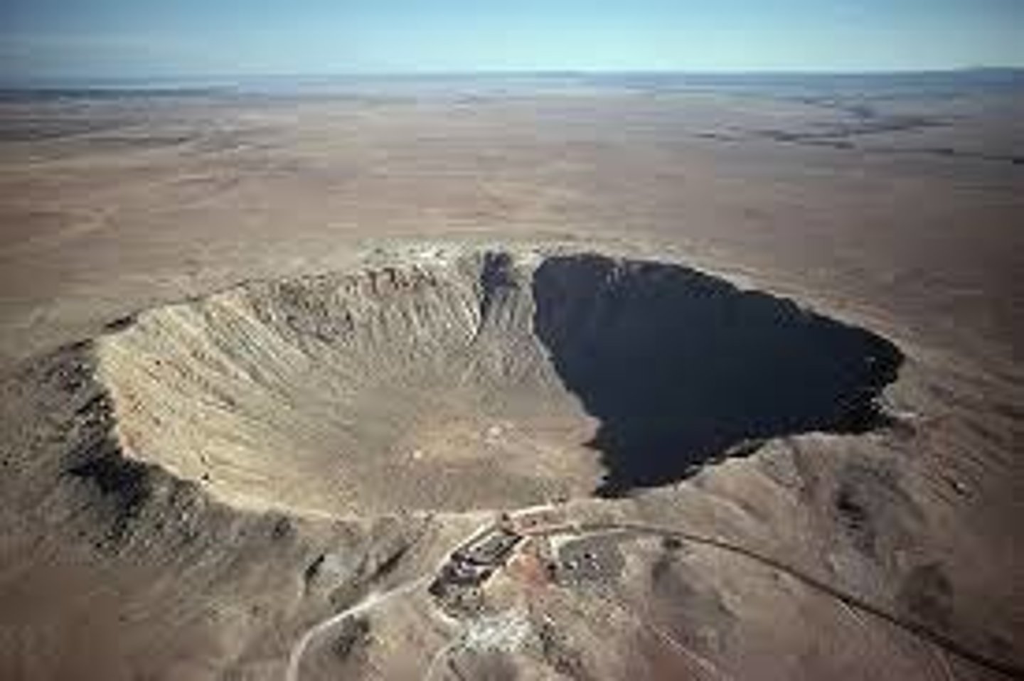 <p>A large round pit caused by the impact of a meteoroid.</p>