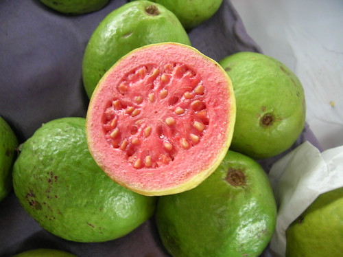 round shape that comes to a top point. The outside is light green-green and has a rough texture. The inside is either pink-red, as shown, or white, as shown. There are small seeds dotted around the fruit.