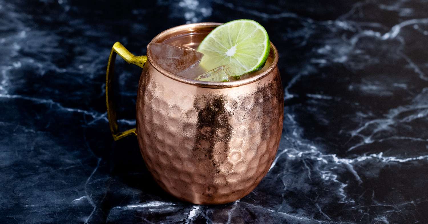 <p>highball, 1.5 oz vodka, 4 oz ginger beer, 0.25 oz lime juice, served in a copper mug, garnished with lime</p>