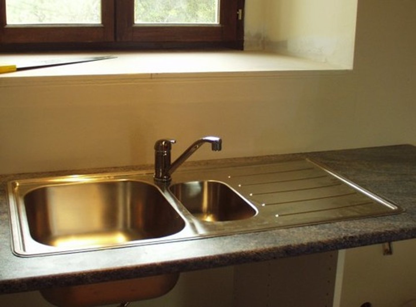 <p>a basin, as in a kitchen or laundry, connected with a water supply and drainage system for washing</p>