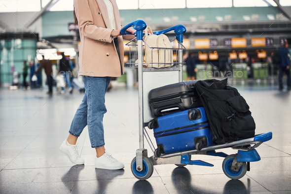 a large container with wheels that you push and use for carrying things in a supermarket or at an airport