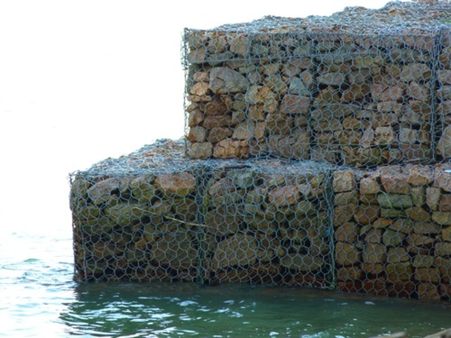 <p>Steel mesh cages filled with small rocks, absorb wave energy.</p>