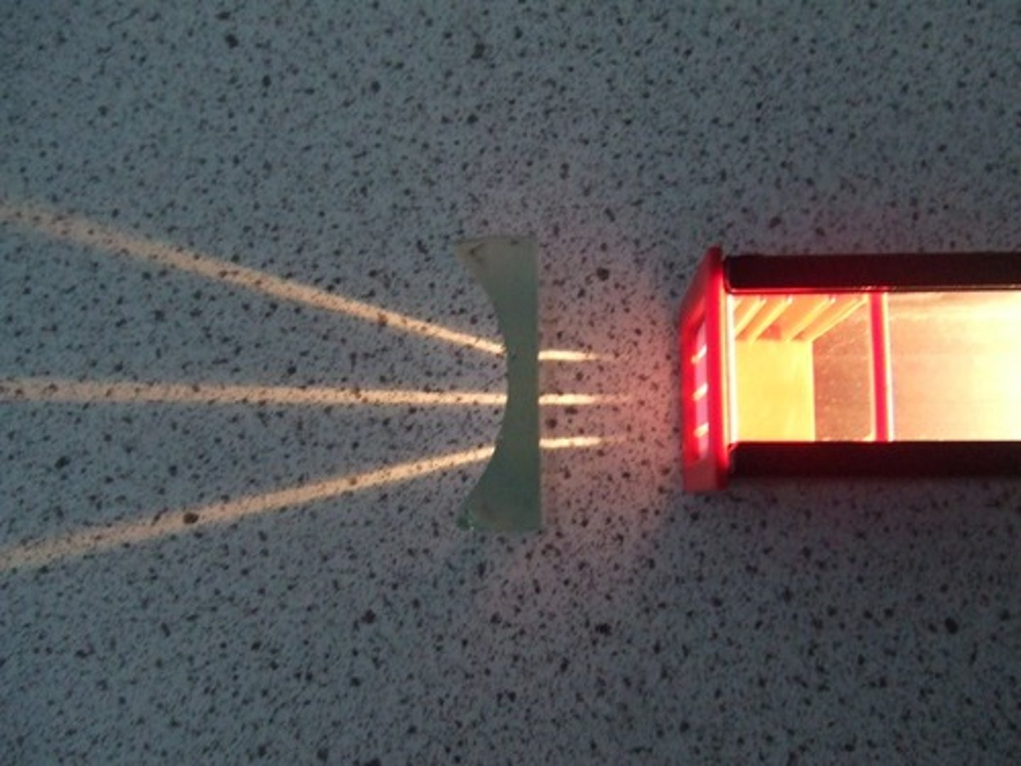 <p>a lens that is thicker at the edges than in the middle that bends light rays away from one another. refracts light away from a focal point. (flashlights)</p>