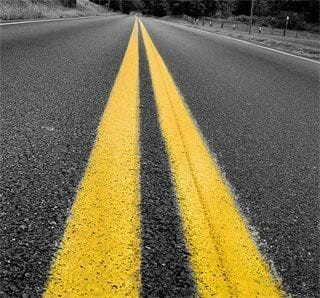 Do not cross a solid double yellow line in the center of the roadway to:
