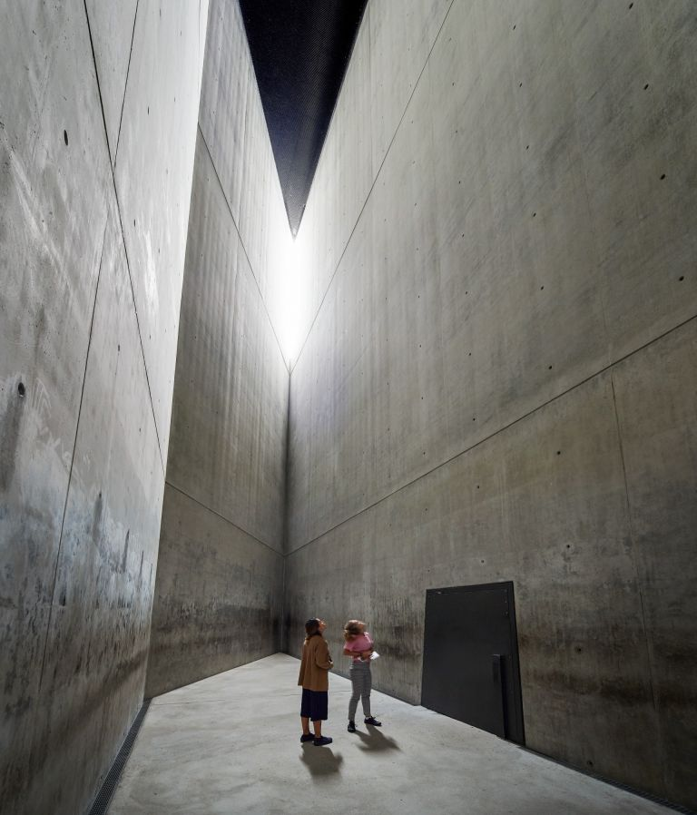 <ol><li><p><strong>materials </strong>- concrete for a brutalist and cold feel</p></li><li><p><strong>height and emptiness</strong> - narrow, unheated, completely empty vertical space</p></li><li><p><strong>access </strong>- entered through a heavy steel door, making users feel trapped</p></li><li><p><strong>emotional impact</strong> - designed to evoke feelings of distress, isolation, fear, and the profound absence of life</p></li></ol><p></p>