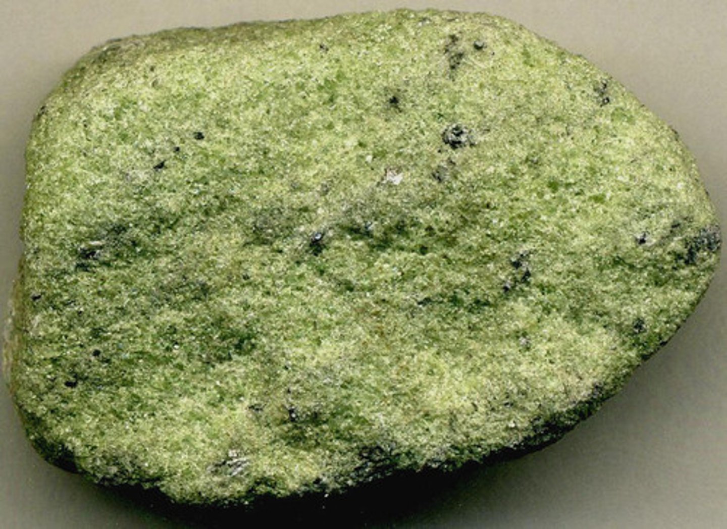 <p>F,I,M,UM: Ultra-mafic<br>Texture: fine-grained<br>Mineral composition: pyroxene, plagioclase, olivine<br>Other properties: yellow/green color due to olivine content<br>Inferred rock origin: intrusive. Essentially it's peridotite but it consists of a lot of olivine.</p>